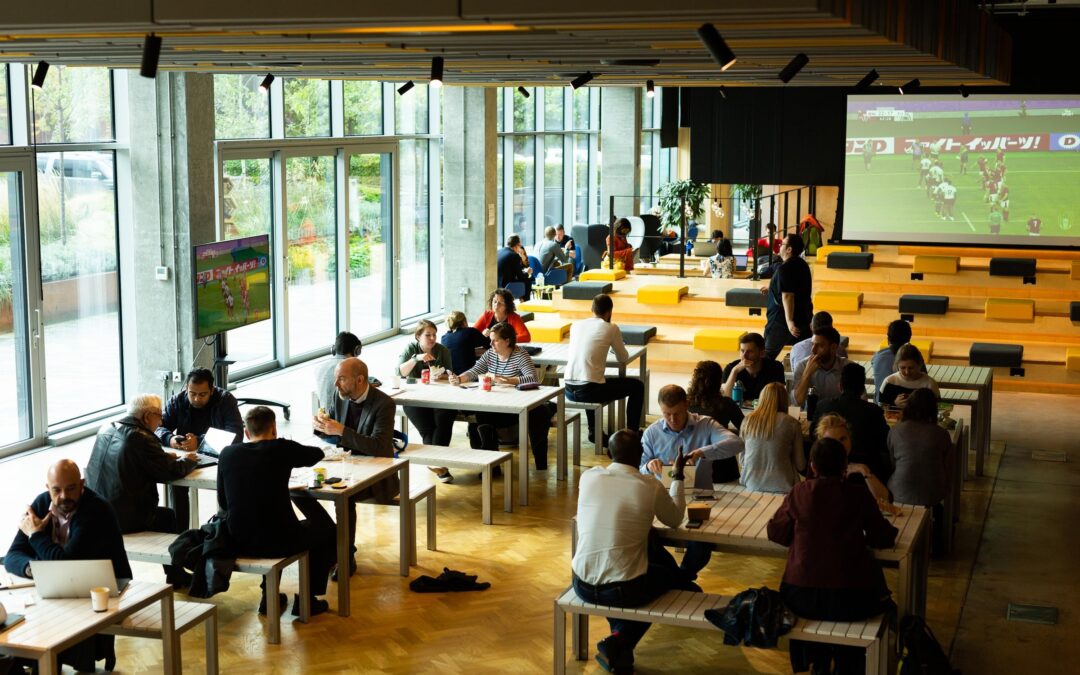 large open events space with tables, bleacher seating and large screen