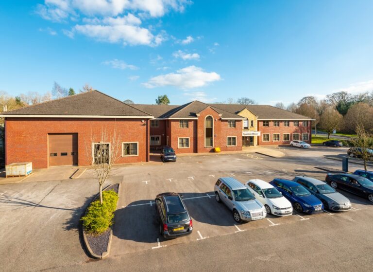 external shot of brown brick 2 storey office building with sycamore house signage