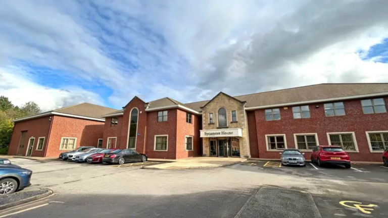 sycamore house sign on exterior of red brick office building