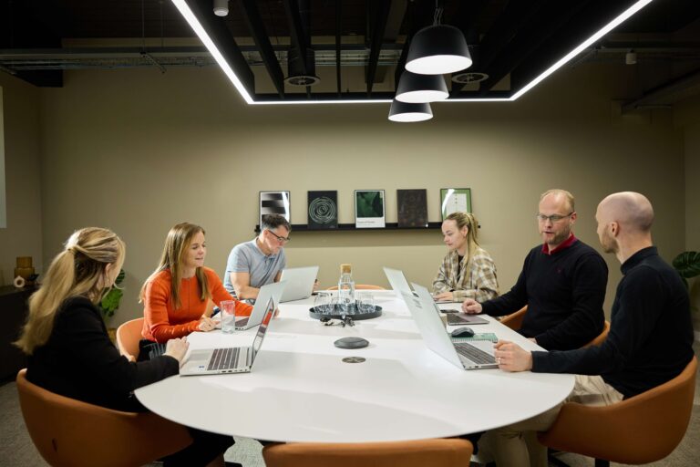 people sat around conference table in meeting room at alderley park