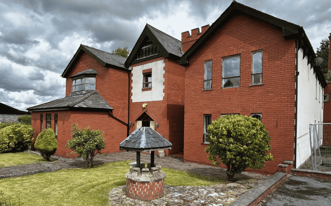 large red brick house with well in front garden